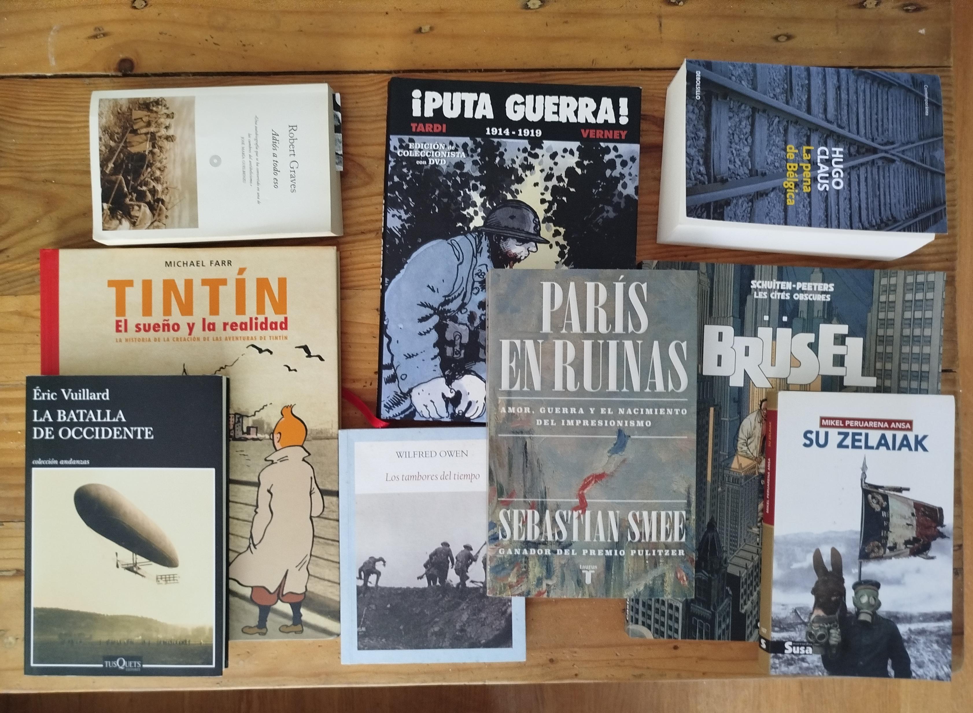 Egingo dugun bidaiarekin lotutako liburu eta komiki sorta mahai gainean.