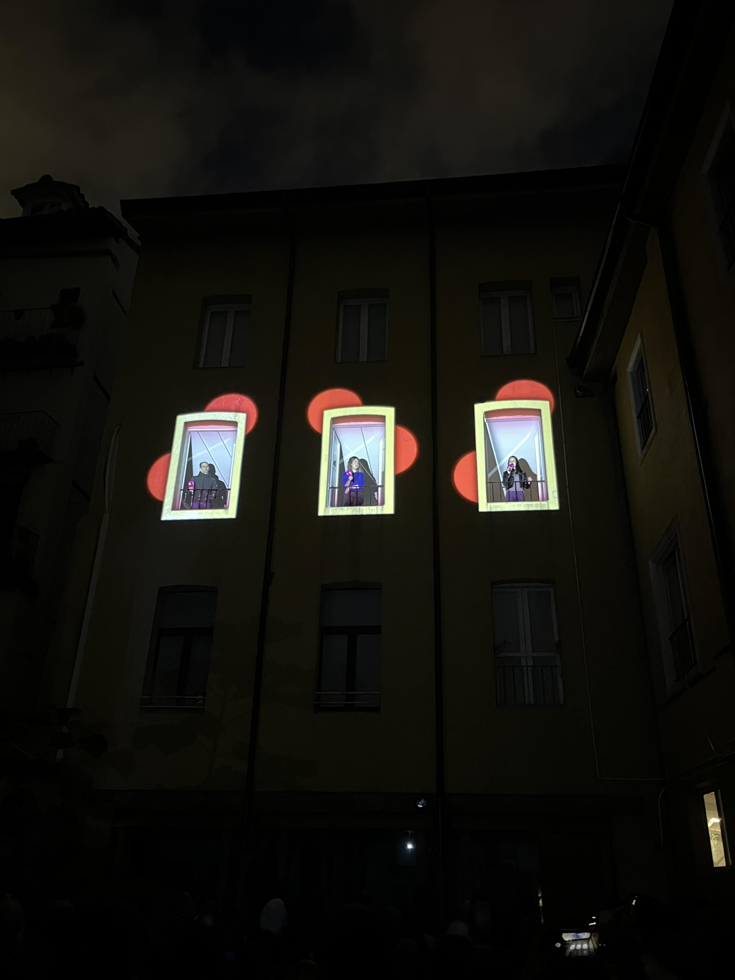 Fatxada bera baina marko txuriak erdiko pisuaren hiru leihoetan baino ez daude, markoen atzetik borobil larroxa bina agertzen dira dekorazio moduan eta leihoetan benetako Sustrai Colina, Sarai Robles eta Idoia Granizo bertsolariak ageri dira, bertan bertsotan ibili zirela.