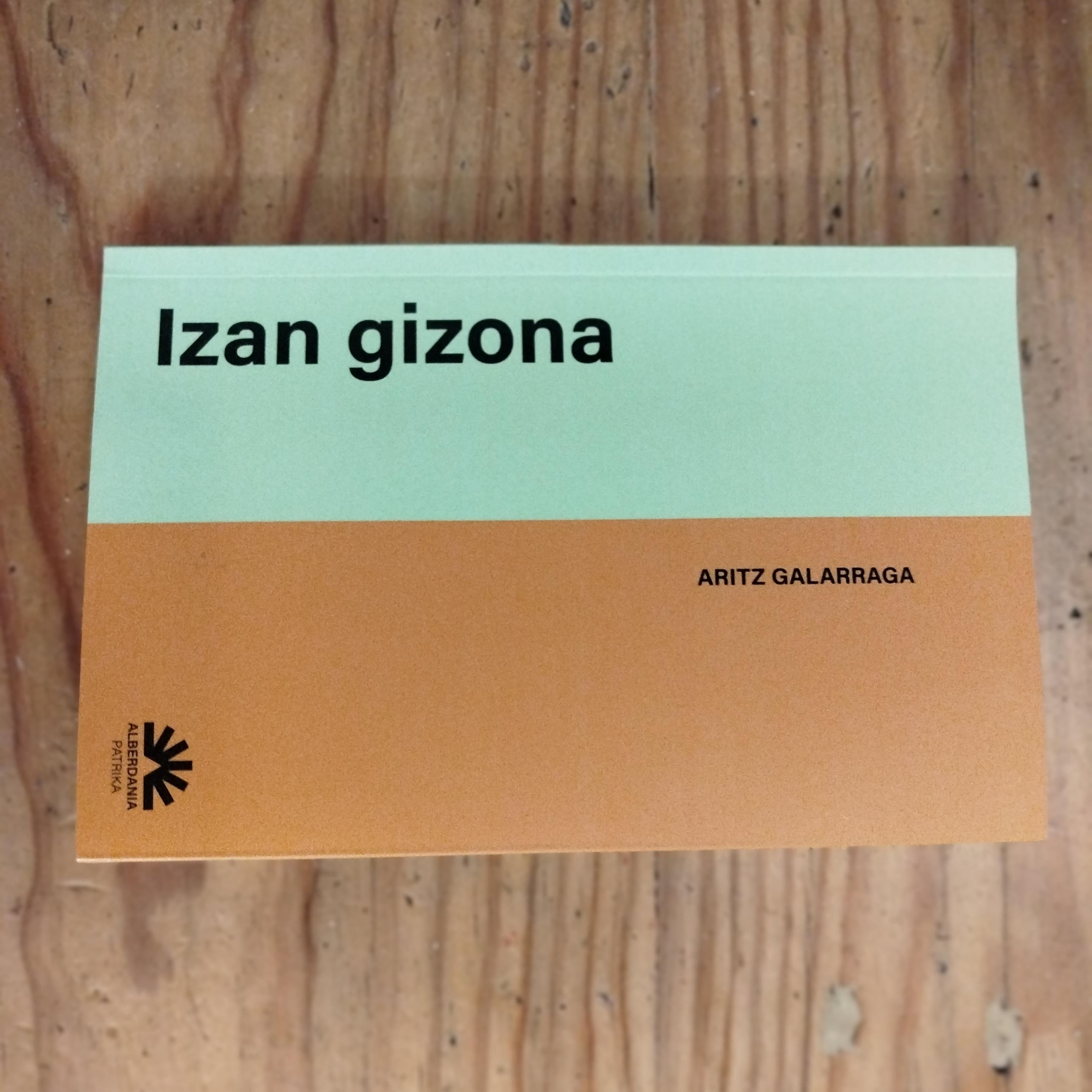 Izan gizona liburua egurrezko mahai baten gainean.